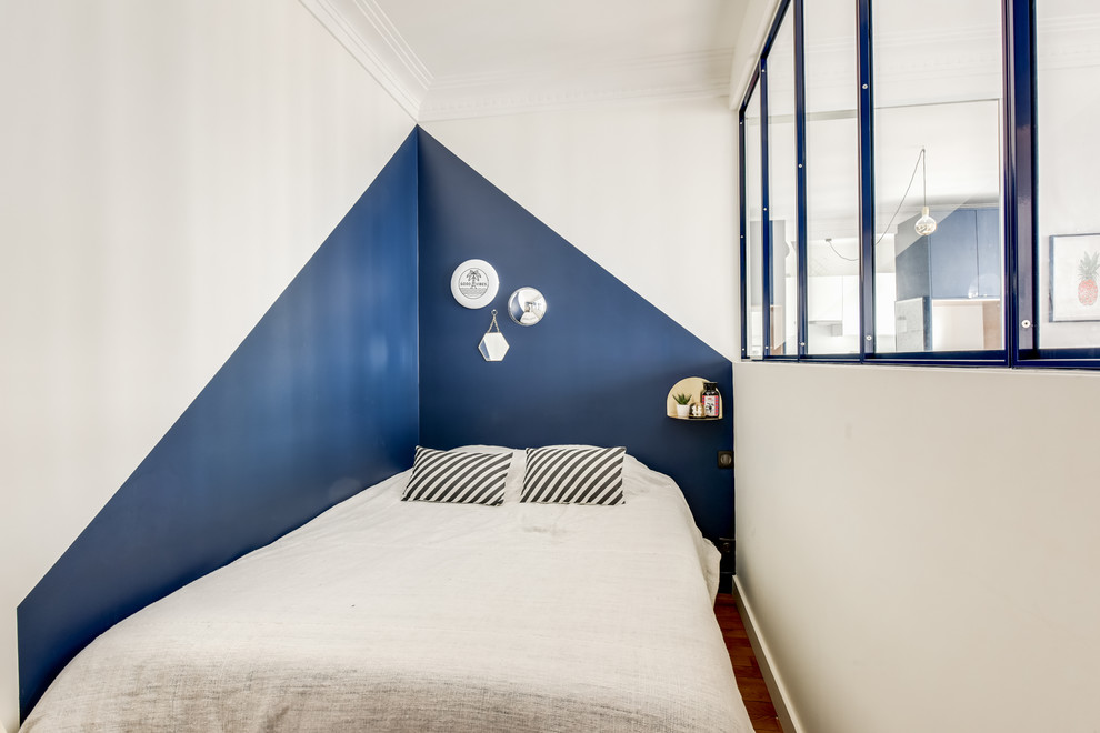 パリにあるコンテンポラリースタイルのおしゃれな寝室 (青い壁、無垢フローリング)