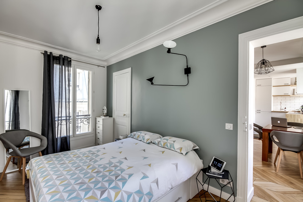 Imagen de dormitorio principal nórdico de tamaño medio sin chimenea con paredes blancas, suelo de madera en tonos medios y suelo marrón