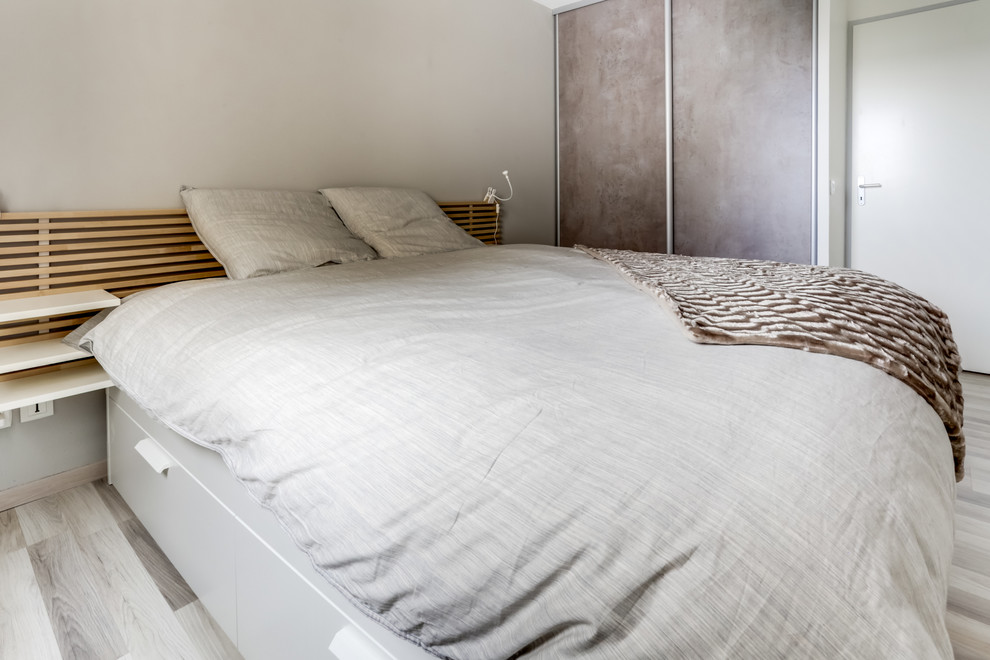 Bild på ett litet minimalistiskt huvudsovrum, med grå väggar, laminatgolv och grått golv