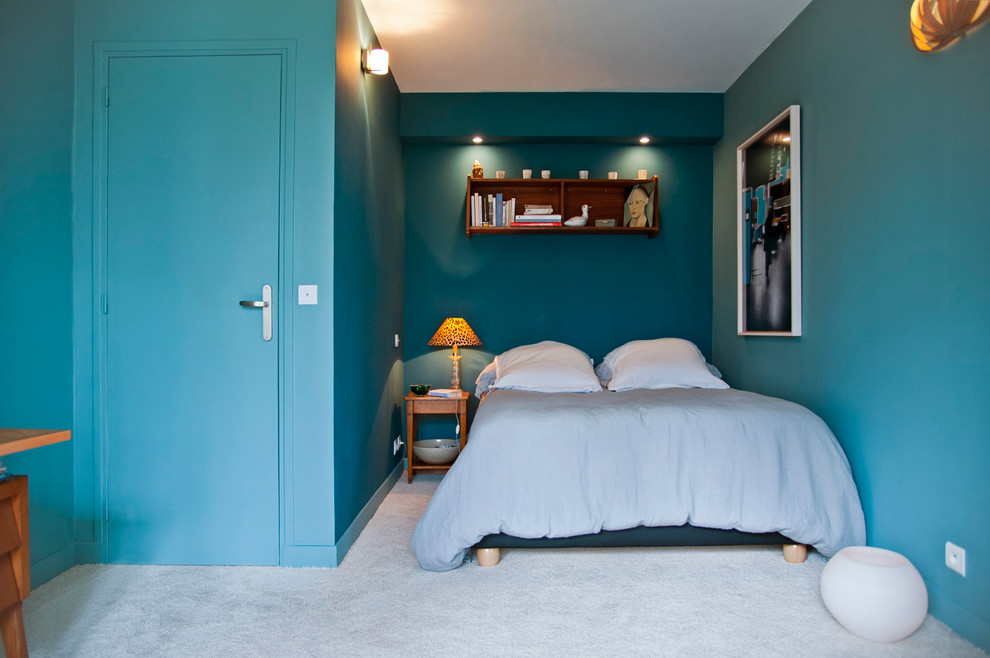 Immagine di una camera matrimoniale contemporanea di medie dimensioni con pareti blu e moquette