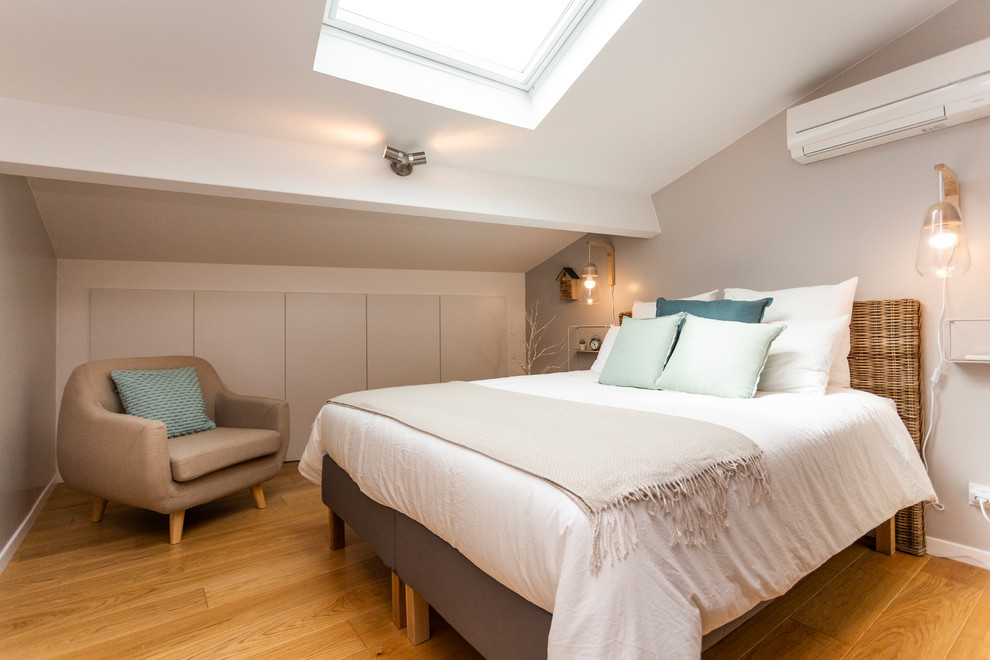 Modelo de dormitorio tradicional renovado con paredes grises, suelo de madera en tonos medios y suelo marrón