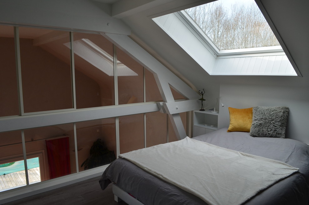 Diseño de dormitorio principal actual de tamaño medio sin chimenea con paredes blancas, suelo laminado y suelo gris