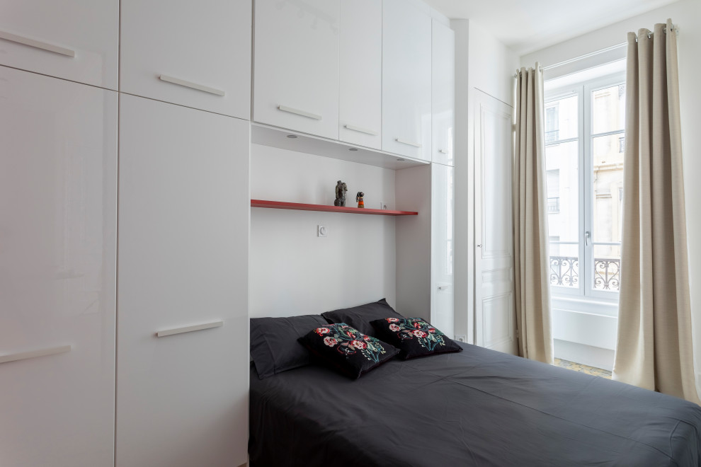 Modelo de dormitorio principal moderno pequeño sin chimenea con paredes blancas, suelo de baldosas de cerámica y suelo multicolor