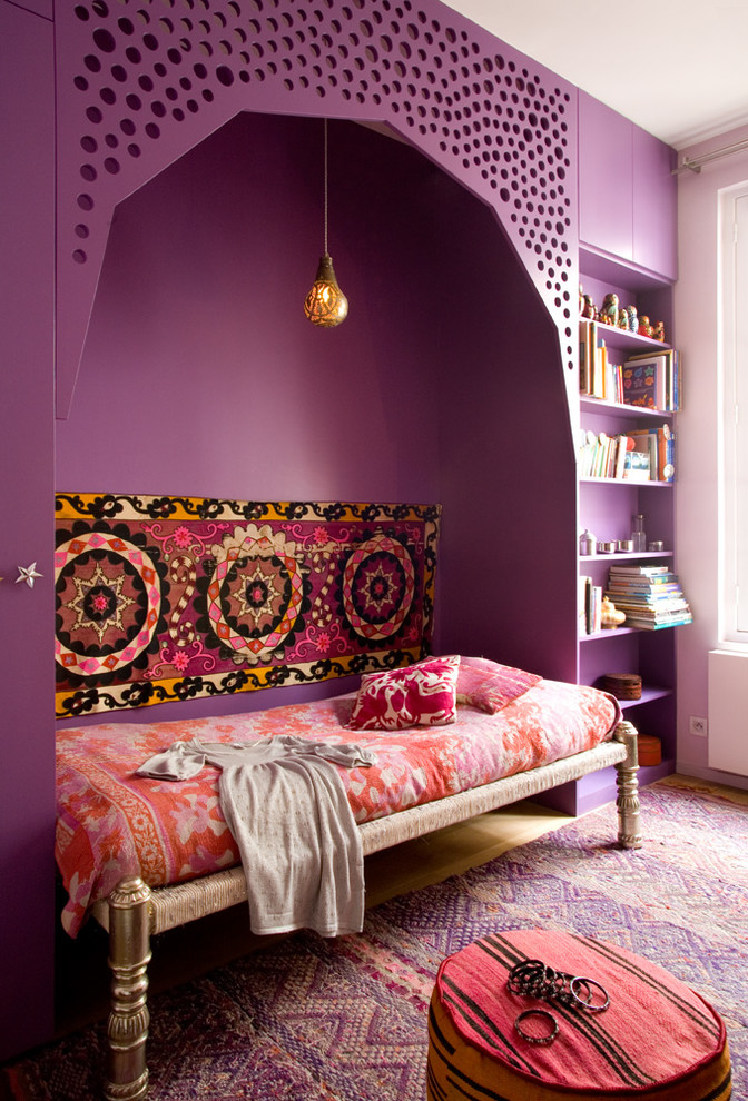 Bohemian master bedroom in Paris with purple walls, light hardwood flooring and no fireplace.