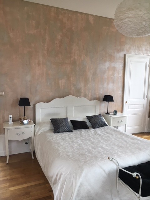 Modelo de dormitorio principal tradicional renovado grande con paredes rosas y suelo de madera clara