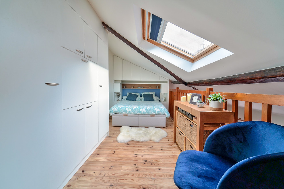 Diseño de dormitorio tipo loft y abovedado contemporáneo con paredes blancas, suelo de madera clara y suelo beige