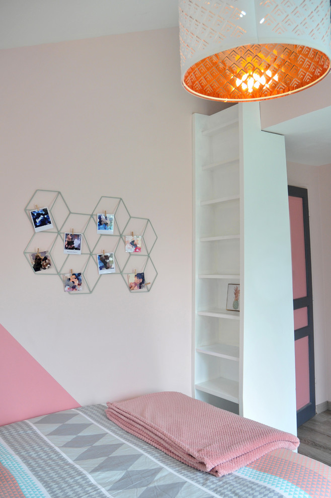 Idées déco pour une chambre mansardée ou avec mezzanine moderne de taille moyenne avec un mur rose et un sol gris.