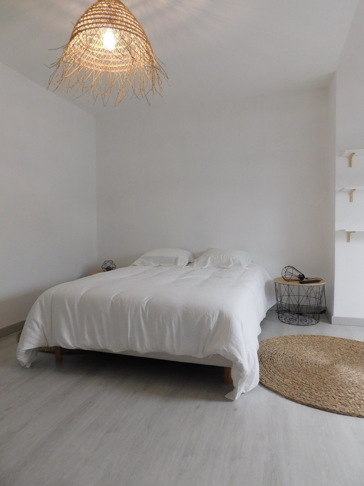 Modelo de dormitorio principal industrial grande con paredes blancas, suelo de madera clara y suelo blanco