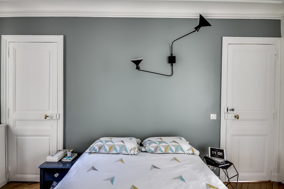 Mittelgroßes Nordisches Hauptschlafzimmer ohne Kamin mit weißer Wandfarbe, braunem Holzboden und braunem Boden in Paris