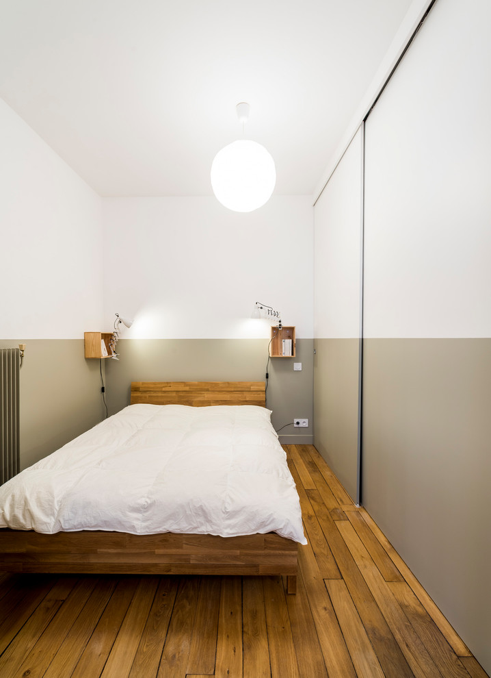 Mittelgroßes Industrial Hauptschlafzimmer mit grauer Wandfarbe, braunem Holzboden und beigem Boden in Marseille