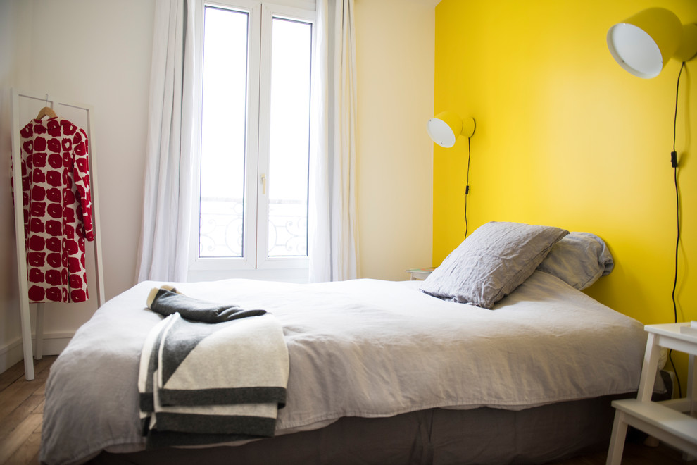 Exemple d'une petite chambre parentale chic avec un mur jaune, parquet clair, aucune cheminée et un sol marron.