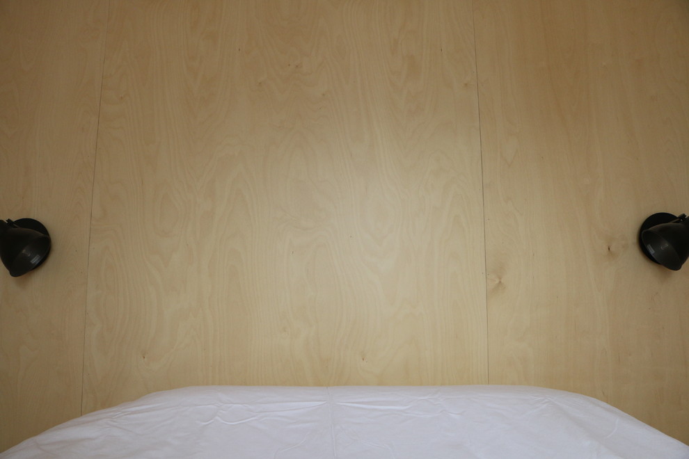 Cette photo montre une petite chambre parentale scandinave avec un mur marron, parquet clair, aucune cheminée et un sol marron.