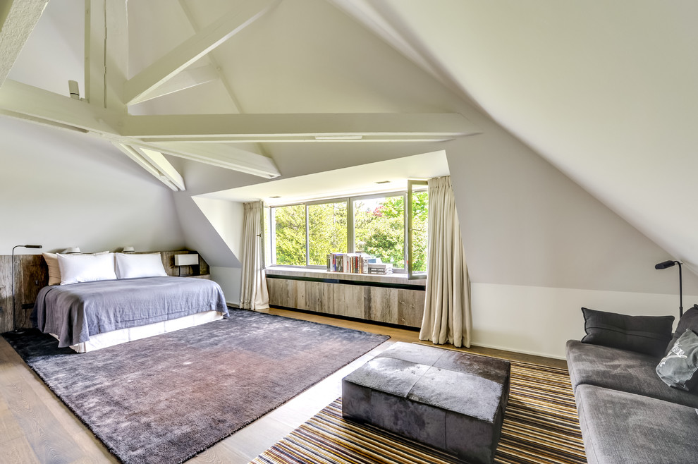Großes Klassisches Schlafzimmer ohne Kamin mit weißer Wandfarbe und hellem Holzboden in Paris