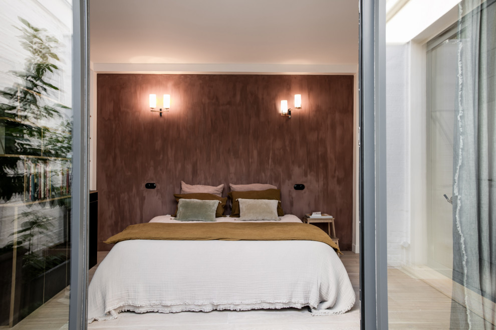 Стильный дизайн: хозяйская спальня в скандинавском стиле с красными стенами и светлым паркетным полом - последний тренд