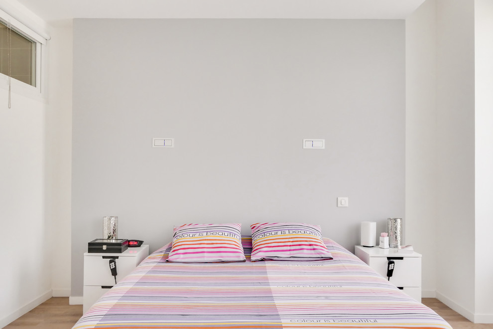 Идея дизайна: большая хозяйская спальня в современном стиле с белыми стенами, полом из ламината и коричневым полом без камина