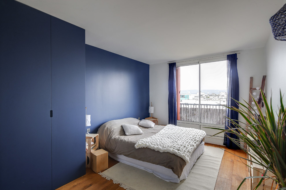 パリにある中くらいなコンテンポラリースタイルのおしゃれな主寝室 (青い壁、無垢フローリング、暖炉なし、茶色い床)