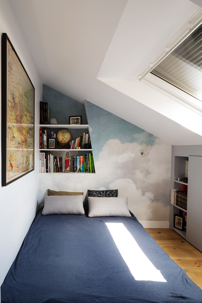 Imagen de dormitorio contemporáneo con paredes blancas, suelo de madera clara y suelo marrón