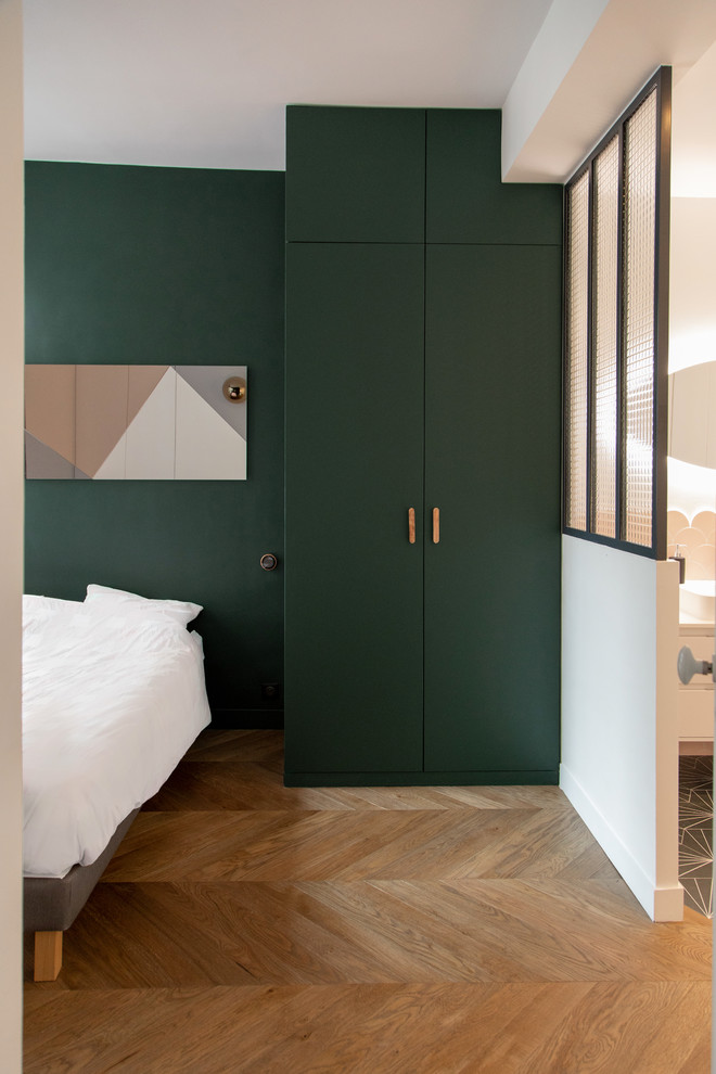 Esempio di una camera matrimoniale minimalista di medie dimensioni con pareti verdi, pavimento in legno massello medio, nessun camino e pavimento marrone