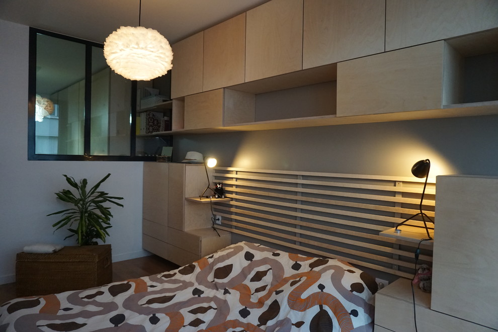 Idée de décoration pour une chambre parentale de taille moyenne avec un mur marron, un sol en bois brun et un sol marron.
