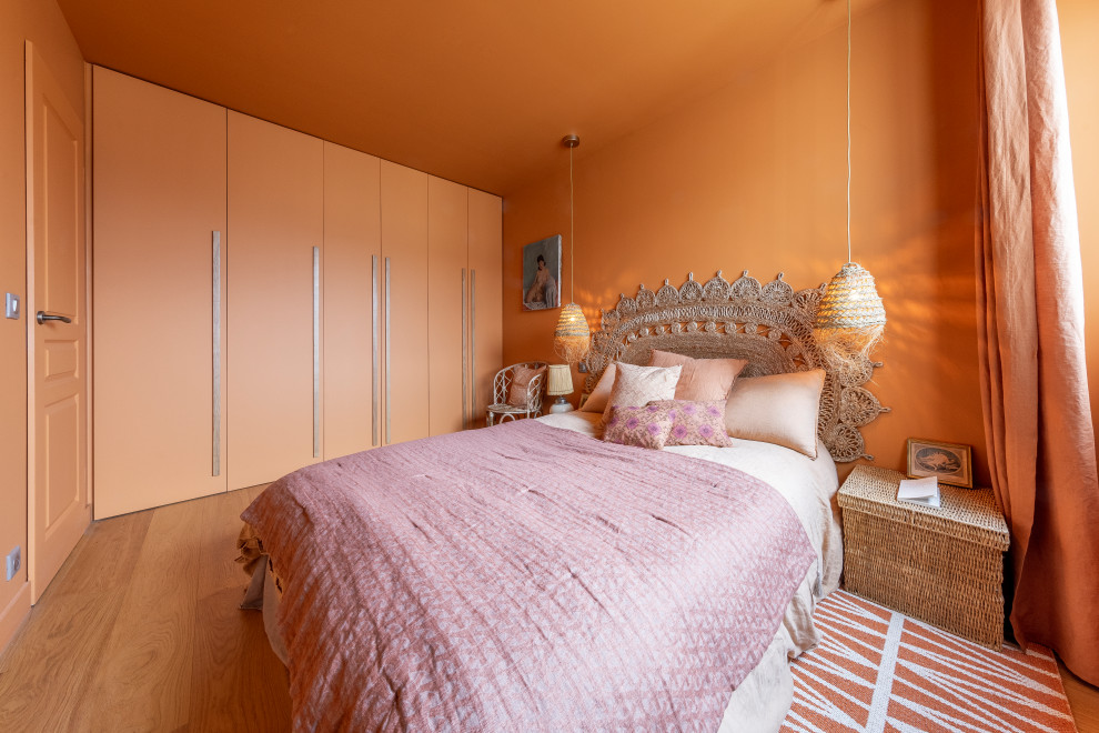 Idee per una camera matrimoniale contemporanea di medie dimensioni con pareti arancioni, parquet chiaro, nessun camino e pavimento beige