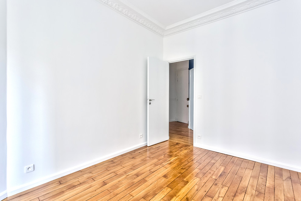 Foto di una grande camera matrimoniale chic con pareti bianche, pavimento in legno massello medio e pavimento marrone