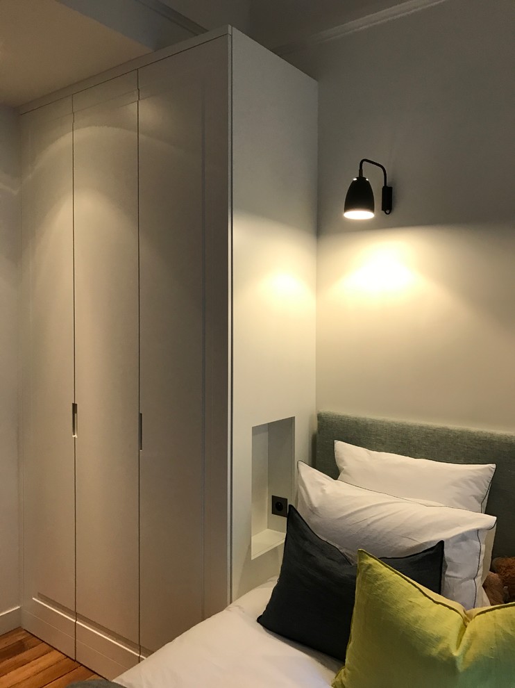 Modelo de dormitorio principal contemporáneo de tamaño medio con paredes beige y suelo de madera oscura
