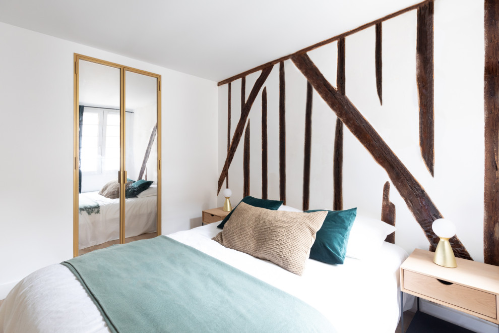 Foto de dormitorio principal actual pequeño sin chimenea con paredes blancas, suelo de madera clara y suelo marrón