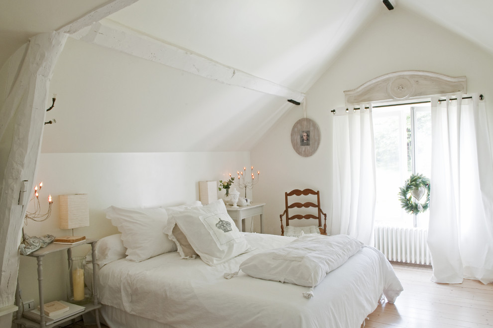 Ejemplo de dormitorio romántico con paredes blancas y suelo de madera clara