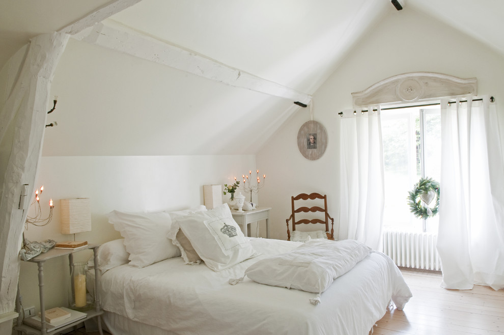 Example of a cottage chic light wood floor bedroom design in Paris with white walls