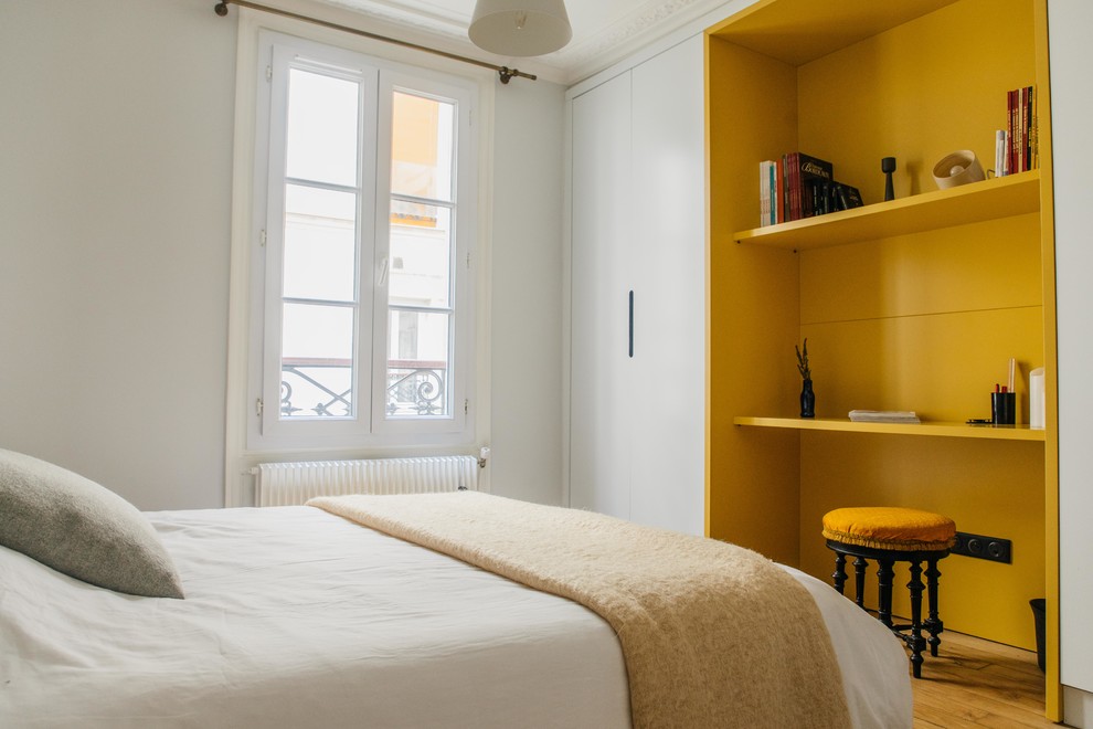 Example of a small trendy guest medium tone wood floor and beige floor bedroom design in Paris with gray walls