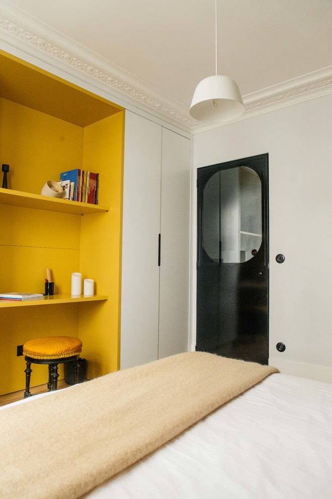 Inspiration pour une petite chambre d'amis design avec un mur gris et parquet clair.