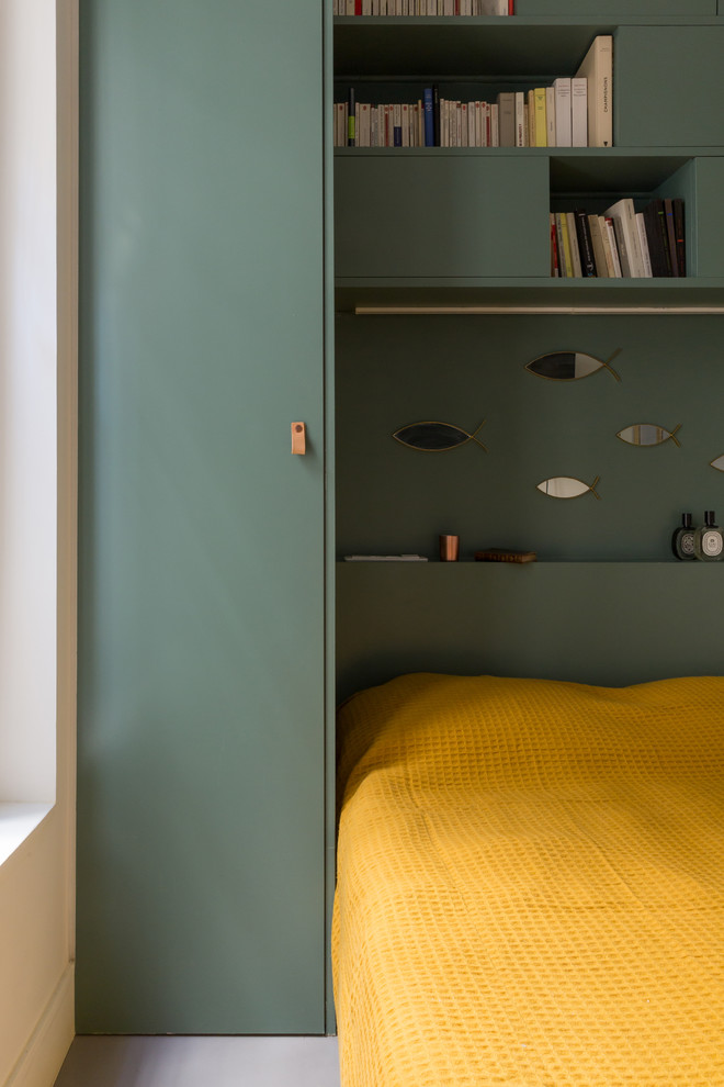 Diseño de dormitorio principal contemporáneo pequeño sin chimenea con paredes verdes, suelo de cemento y suelo gris