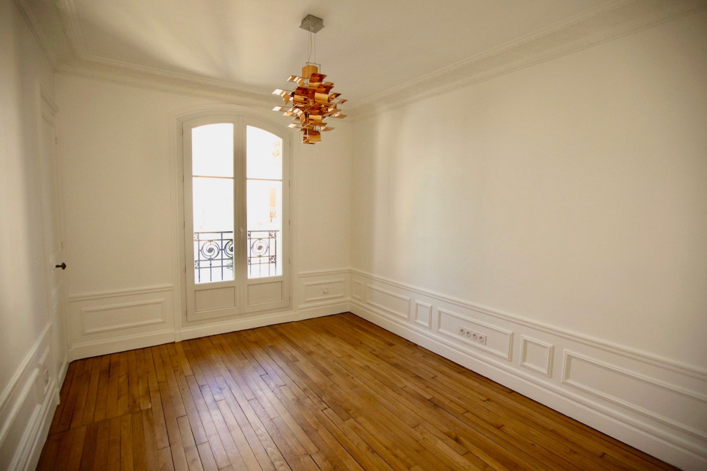 Immagine di una camera degli ospiti chic di medie dimensioni con pareti bianche e pavimento in legno massello medio