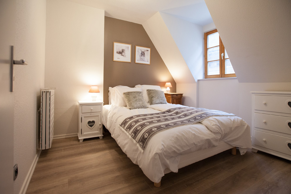 Foto de dormitorio principal campestre pequeño sin chimenea con paredes marrones, suelo laminado y suelo marrón