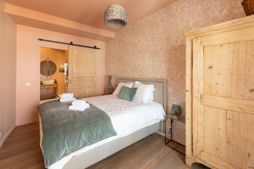 Großes Shabby-Look Hauptschlafzimmer ohne Kamin mit rosa Wandfarbe, hellem Holzboden, beigem Boden und Tapetenwänden in Straßburg