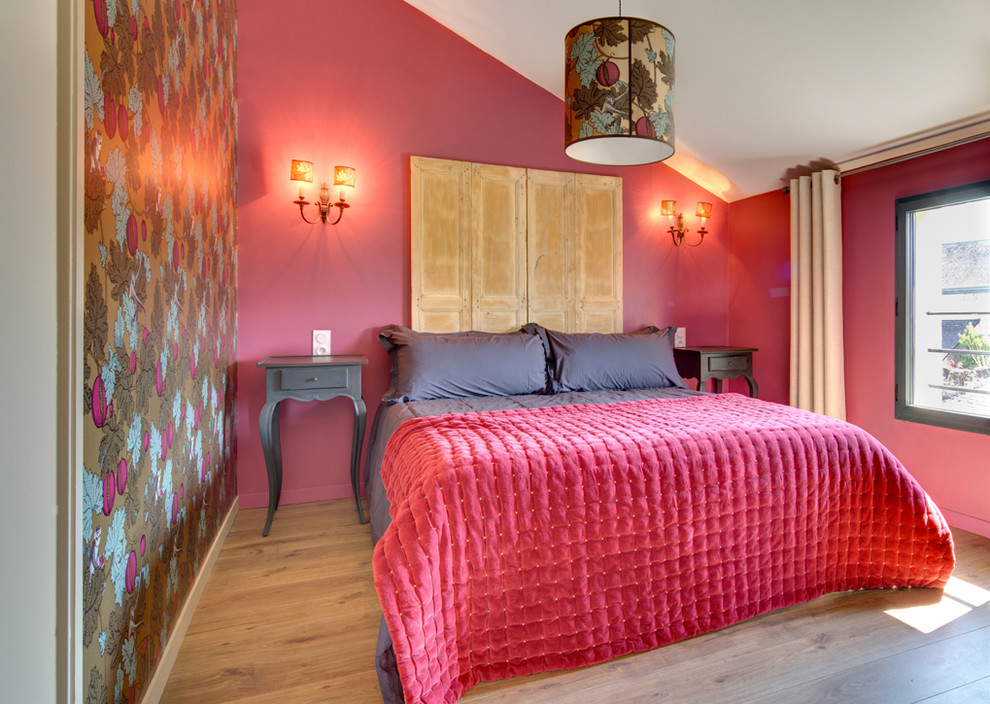 Cette photo montre une chambre méditerranéenne avec un mur rouge, un sol en bois brun et un sol marron.