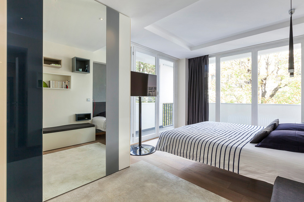 Diseño de dormitorio principal actual grande con paredes beige y suelo de madera clara