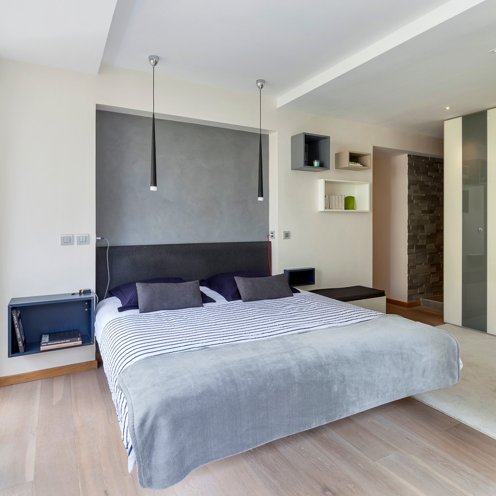 Ejemplo de dormitorio principal actual grande con paredes beige y suelo de madera clara