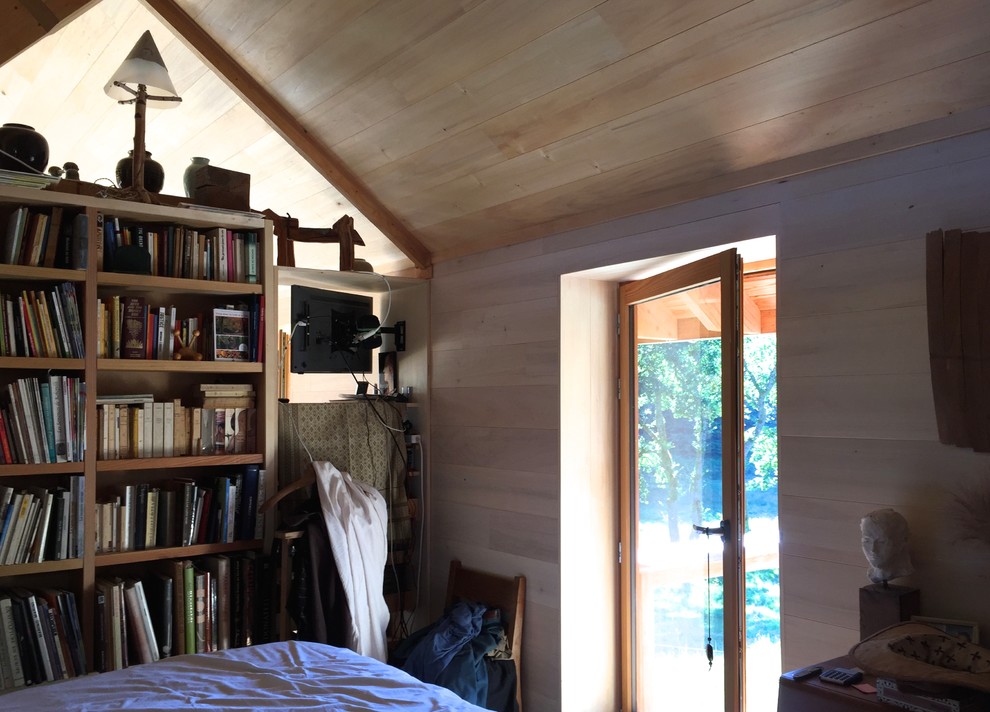 Ejemplo de dormitorio principal de estilo de casa de campo grande sin chimenea con paredes beige, suelo de madera clara y suelo beige