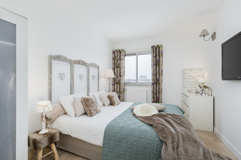 Shabby-Chic Schlafzimmer mit weißer Wandfarbe, hellem Holzboden und beigem Boden in Sonstige