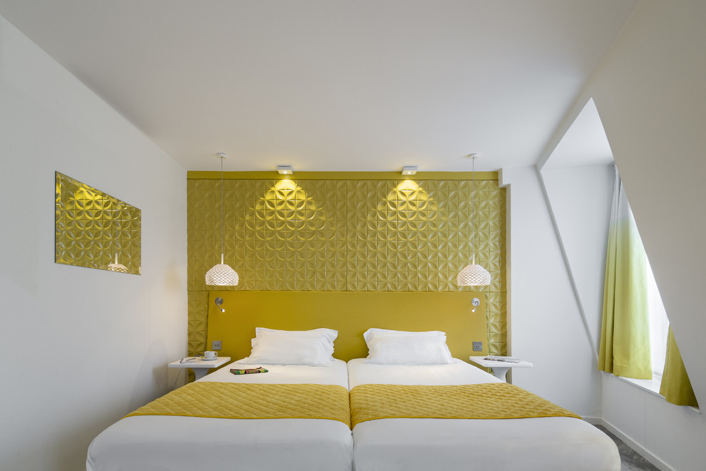 Idée de décoration pour une chambre mansardée ou avec mezzanine design de taille moyenne avec un mur jaune.