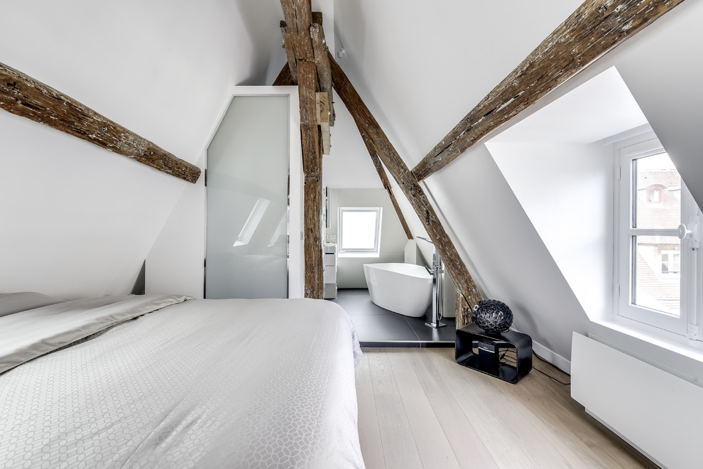 Cette photo montre une chambre parentale blanche et bois tendance avec un mur blanc, parquet clair, aucune cheminée et un sol beige.