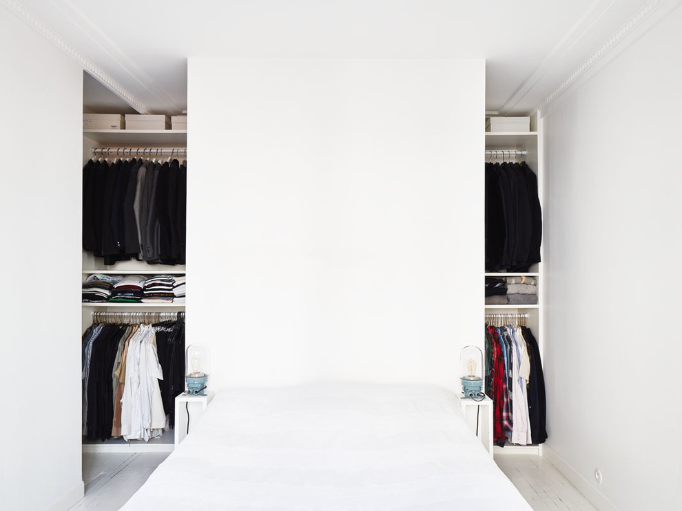 На фото: гардеробная комната среднего размера в скандинавском стиле с открытыми фасадами, белыми фасадами и деревянным полом для мужчин с