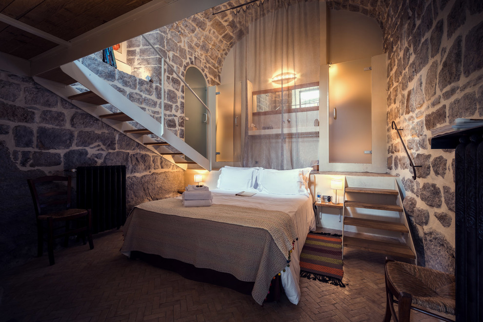 Пример оригинального дизайна: большая хозяйская спальня в стиле рустика с разноцветными стенами и кирпичным полом без камина
