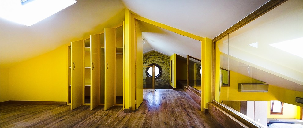 Idée de décoration pour une grande chambre mansardée ou avec mezzanine design avec un mur jaune.