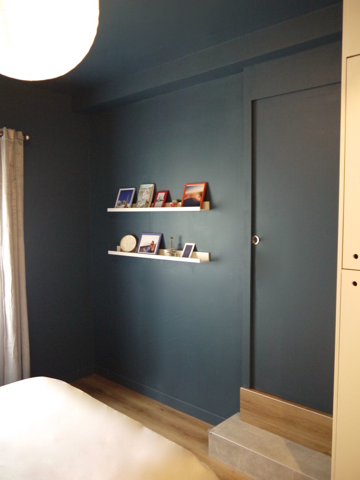 Imagen de dormitorio principal nórdico de tamaño medio con paredes azules, suelo vinílico y suelo beige