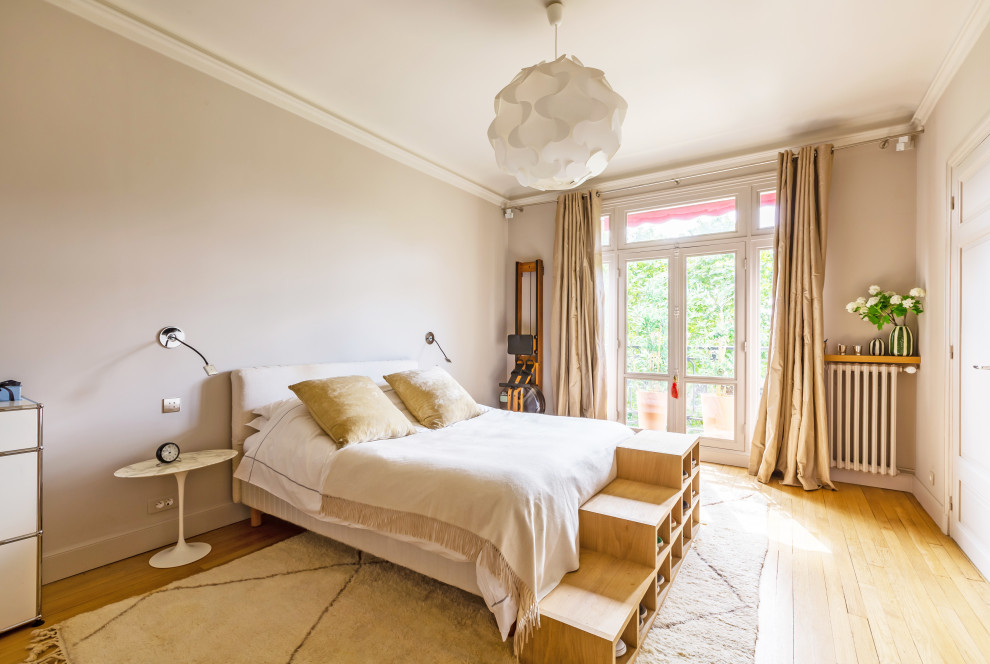 Diseño de dormitorio principal contemporáneo grande sin chimenea con paredes blancas, suelo de madera clara y suelo beige