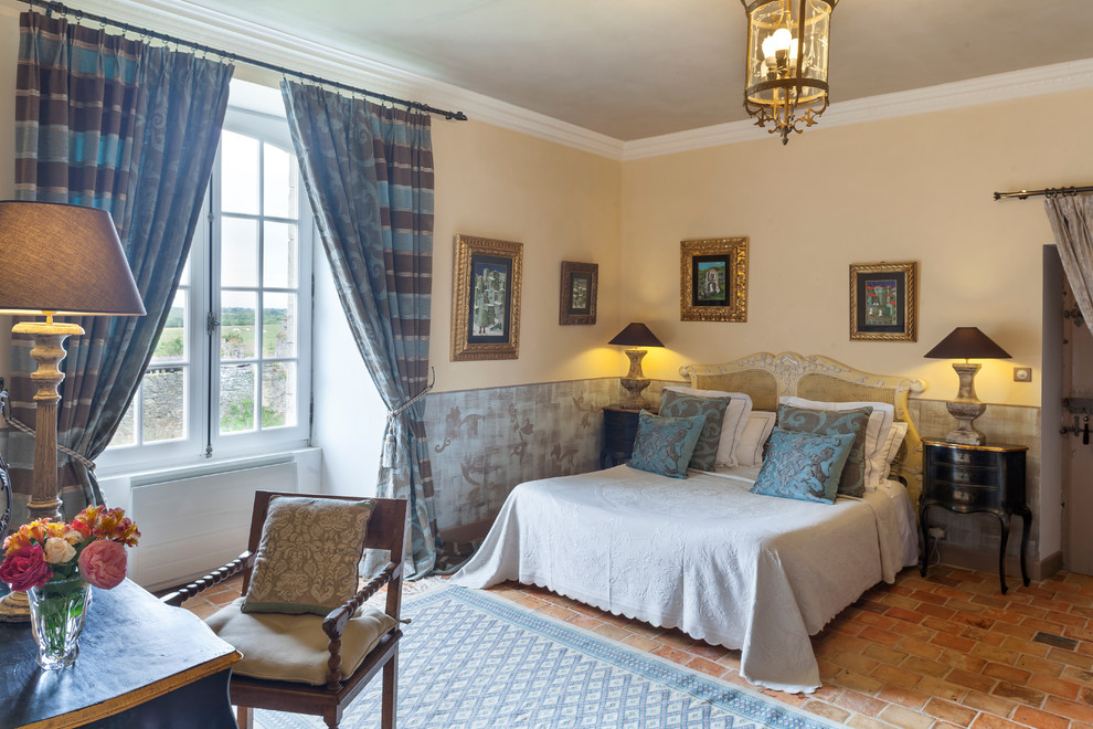 Пример оригинального дизайна: гостевая спальня среднего размера, (комната для гостей) в стиле неоклассика (современная классика) с синими стенами, полом из терракотовой плитки, стандартным камином, фасадом камина из камня и оранжевым полом