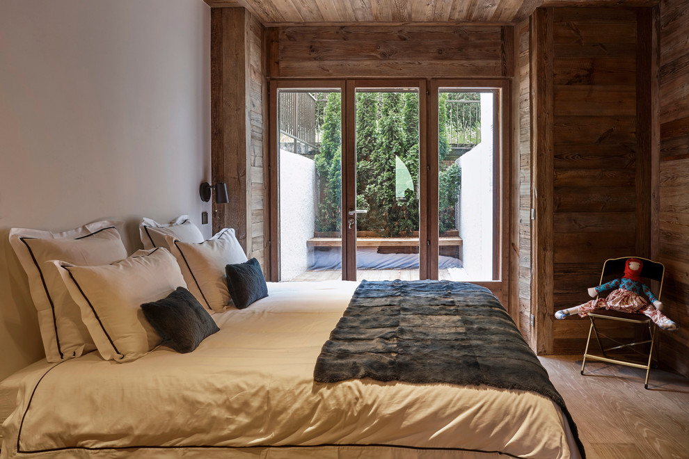 Ejemplo de dormitorio principal minimalista grande con suelo de madera clara