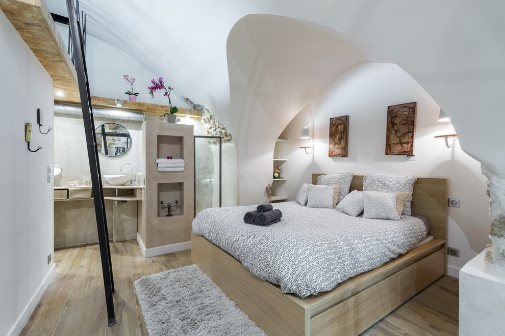 Modelo de dormitorio principal contemporáneo con paredes blancas y suelo de madera clara